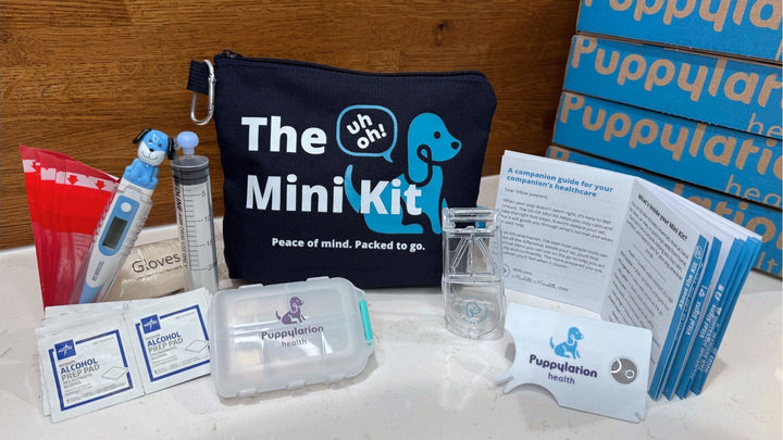 The Uh-Oh Mini Kit by Puppylation Health — compact dog first aid kit with thermometer, pill splitter, gloves, alcohol wipes, and vet-written guide.